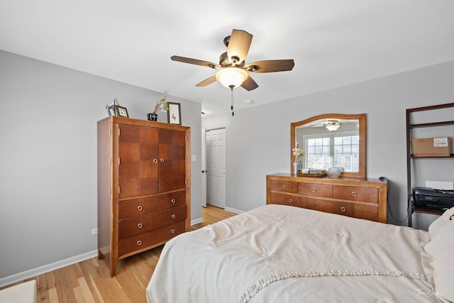 bedroom with ceiling fan, light hardwood / wood-style flooring, and a closet