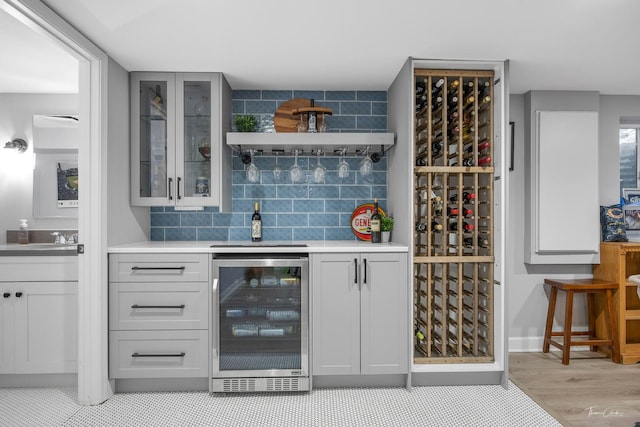 bar featuring decorative backsplash and beverage cooler