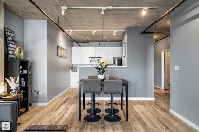 dining area featuring light hardwood / wood-style flooring and rail lighting