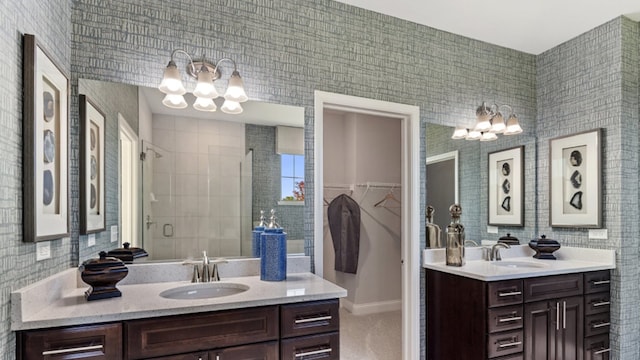 bathroom with vanity, an inviting chandelier, and a shower with door