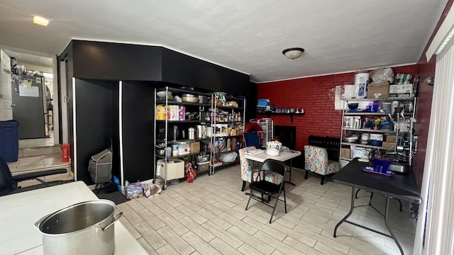 dining space featuring heating unit, a brick fireplace, and light hardwood / wood-style flooring