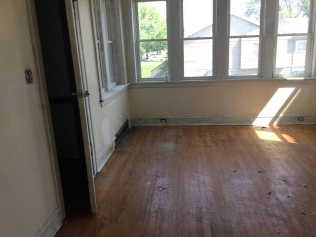 unfurnished room with dark wood-type flooring and plenty of natural light