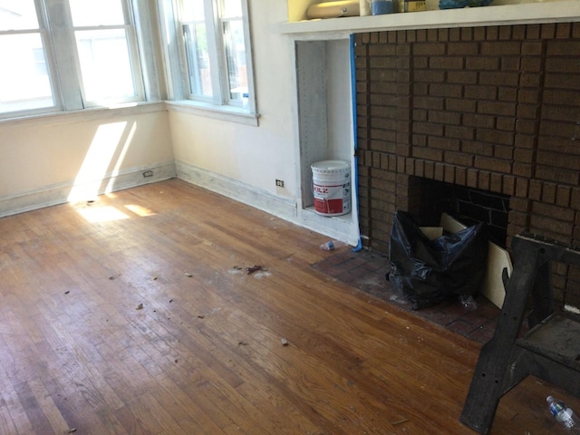 unfurnished dining area with a fireplace and hardwood / wood-style flooring