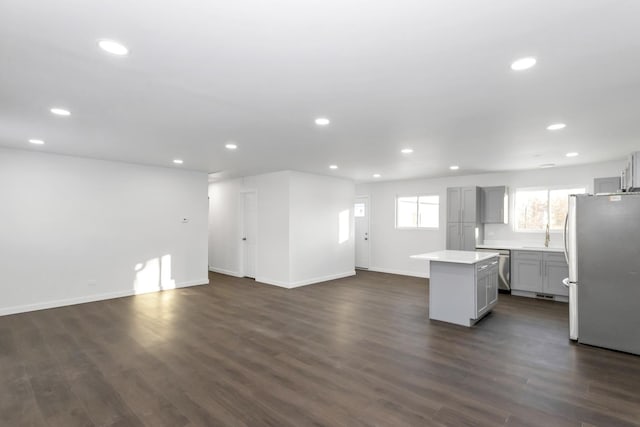 kitchen with dark wood-type flooring, a center island, gray cabinetry, and stainless steel appliances