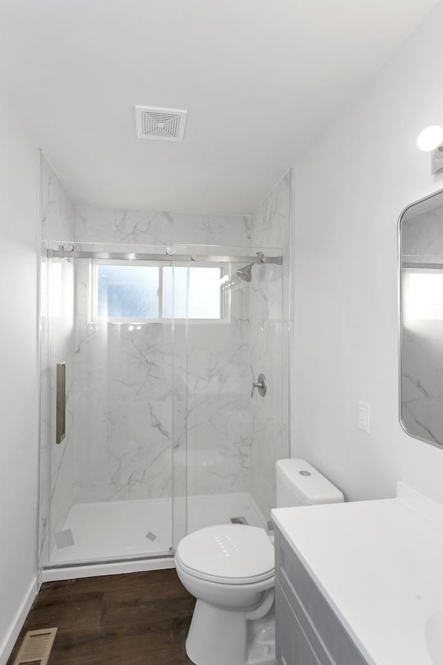 bathroom featuring vanity, hardwood / wood-style flooring, toilet, and walk in shower