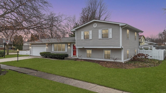 split level home with a lawn and a garage