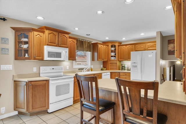 kitchen featuring sink, light tile patterned floors, and white appliances