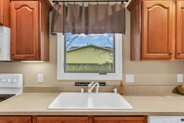 kitchen with sink, white dishwasher, and stove