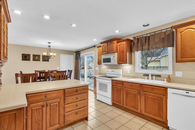 kitchen featuring sink, a chandelier, decorative light fixtures, white appliances, and light tile patterned floors