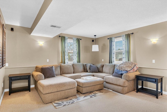 living room featuring a textured ceiling and light colored carpet