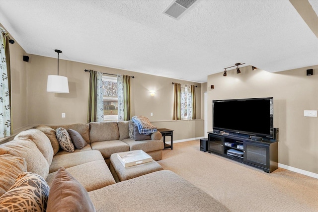 carpeted living room featuring a textured ceiling and rail lighting