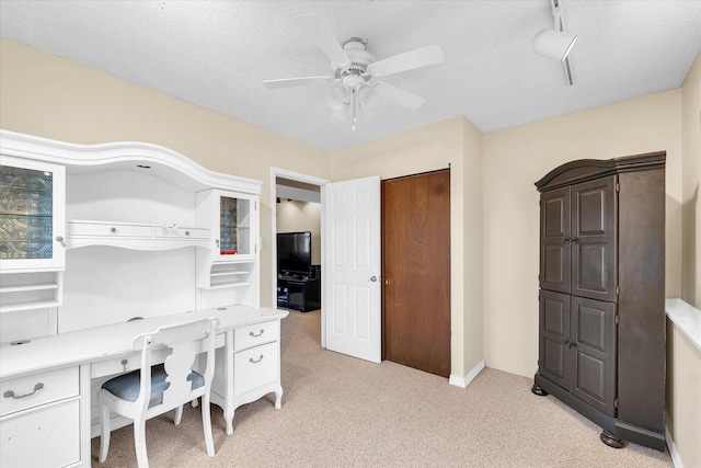 office featuring light carpet, ceiling fan, and a textured ceiling