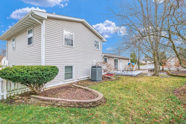 back of house featuring a deck, a yard, and central AC