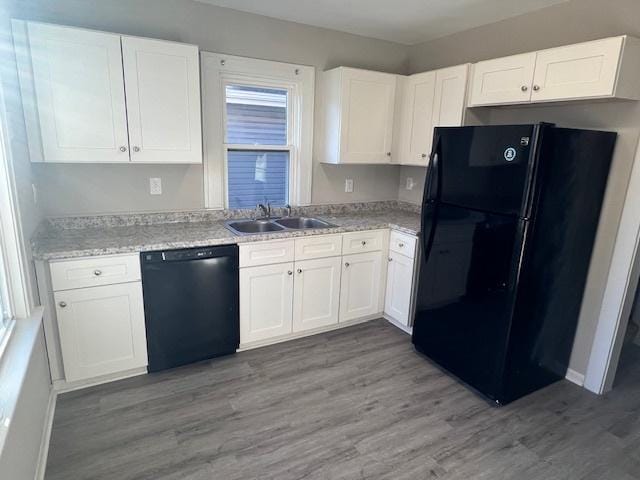 kitchen featuring sink, light hardwood / wood-style flooring, white cabinetry, and black appliances