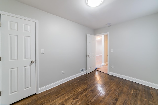 unfurnished room featuring dark wood-type flooring