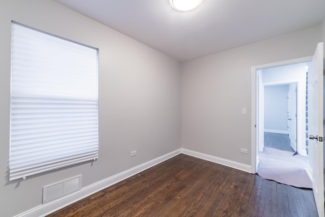 empty room with dark hardwood / wood-style flooring