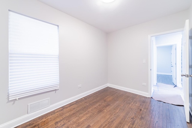 empty room with dark hardwood / wood-style flooring