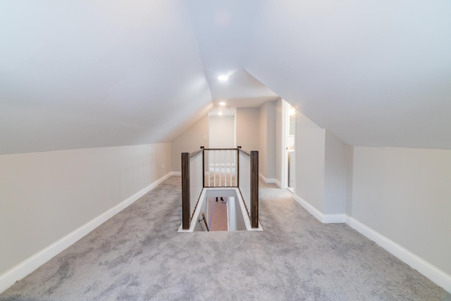 additional living space with light colored carpet and lofted ceiling