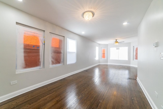 empty room with dark hardwood / wood-style flooring and ceiling fan