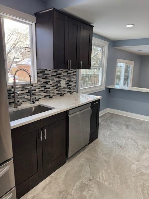 kitchen with dishwasher, sink, and tasteful backsplash