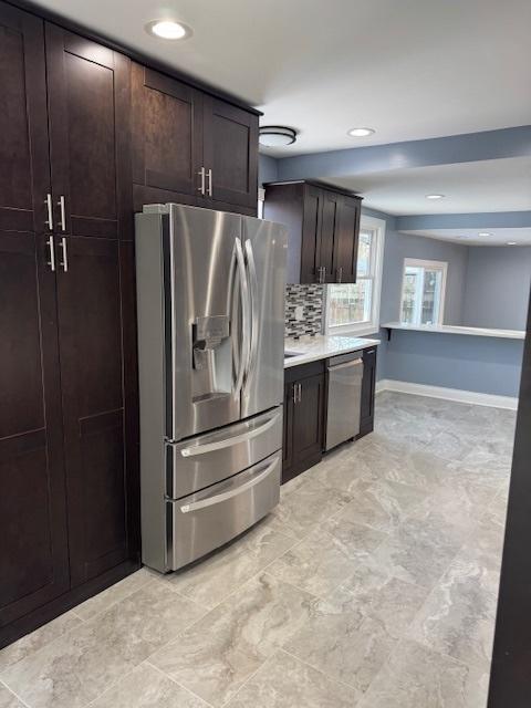 kitchen with decorative backsplash, dark brown cabinetry, and appliances with stainless steel finishes