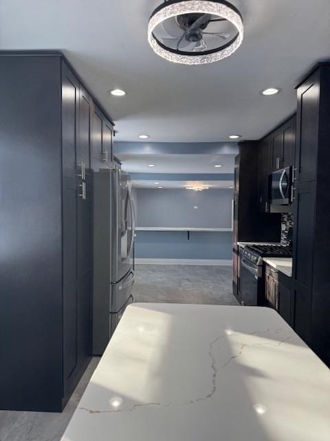 kitchen with light stone countertops and appliances with stainless steel finishes