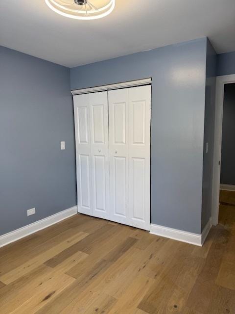 unfurnished bedroom with wood-type flooring and a closet