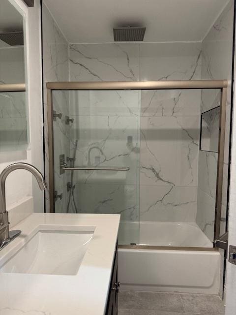 bathroom featuring vanity and bath / shower combo with glass door