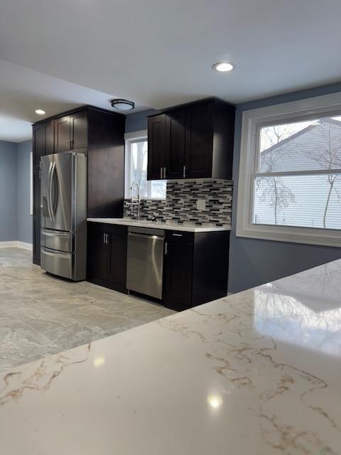 kitchen featuring tasteful backsplash, sink, and appliances with stainless steel finishes