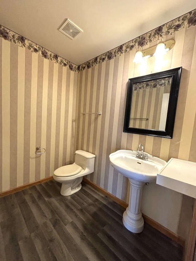 bathroom with hardwood / wood-style flooring and toilet