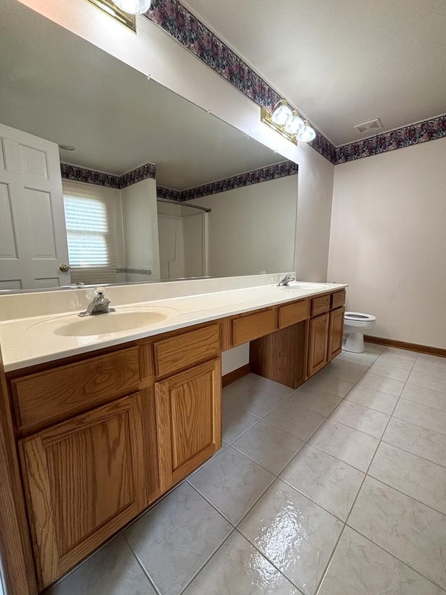 bathroom with tile patterned flooring, vanity, toilet, and a shower