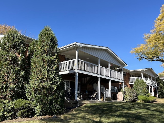 rear view of property with a yard and a balcony