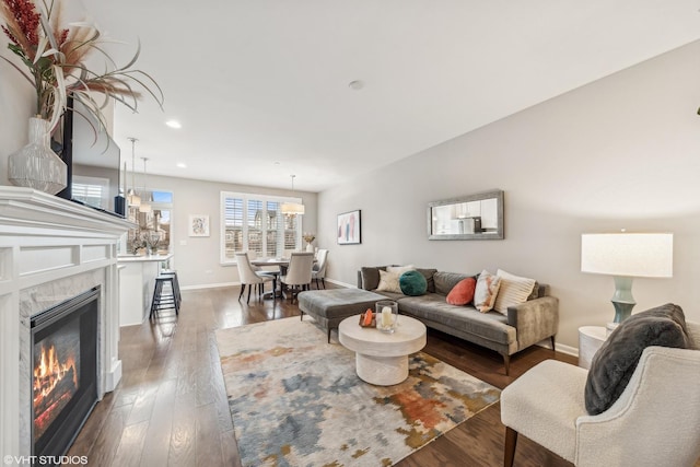 living room with a premium fireplace and dark wood-type flooring