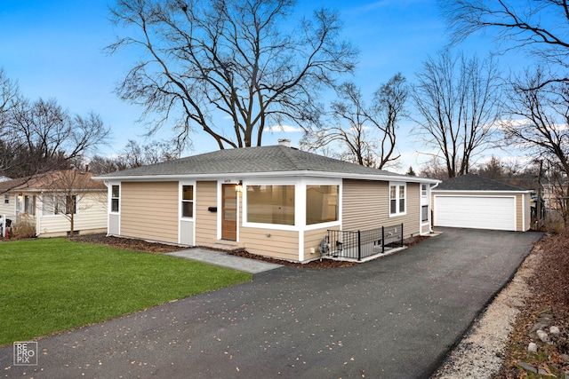 view of front of home with a garage, an outbuilding, and a front yard