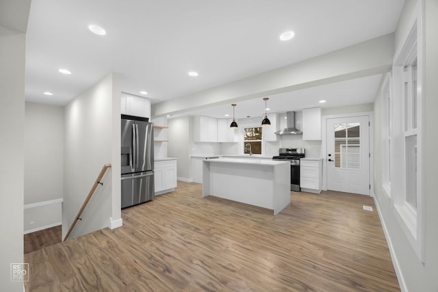 kitchen featuring appliances with stainless steel finishes, a center island, white cabinetry, and hanging light fixtures