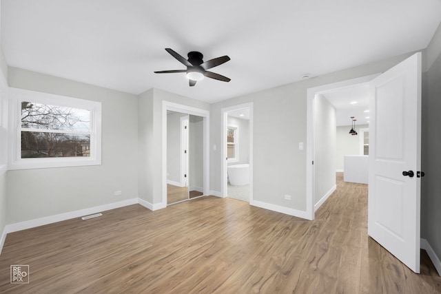 unfurnished bedroom with ceiling fan, light wood-type flooring, and connected bathroom