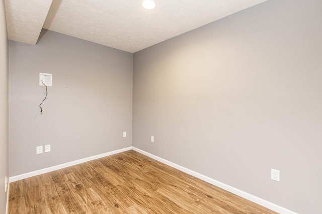 unfurnished room with light hardwood / wood-style floors and a textured ceiling