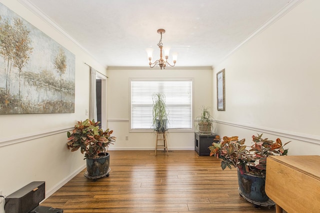 living area featuring dark hardwood / wood-style flooring, crown molding, and a chandelier