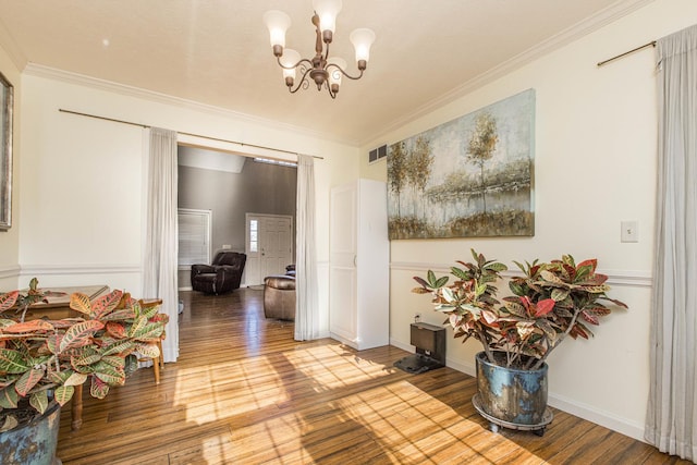 corridor featuring light wood-type flooring, ornamental molding, and an inviting chandelier