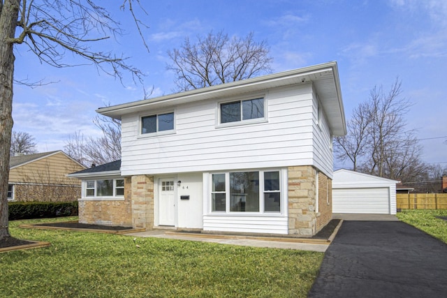 view of property featuring a garage, a front lawn, and an outdoor structure