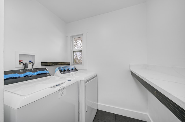 washroom with dark tile patterned floors and washer and dryer