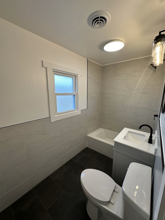 bathroom with tile patterned flooring, vanity, toilet, and tile walls