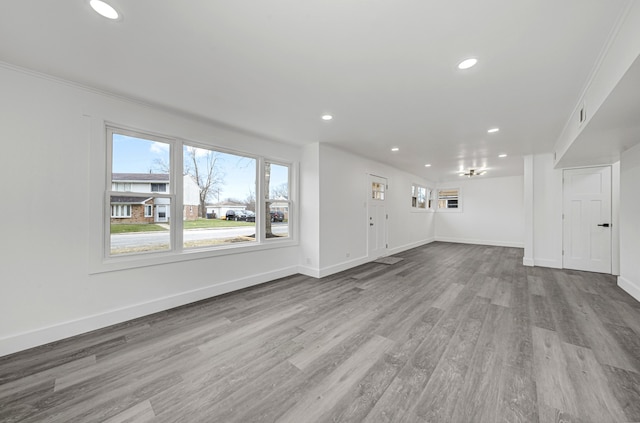 unfurnished living room with light hardwood / wood-style flooring and ornamental molding