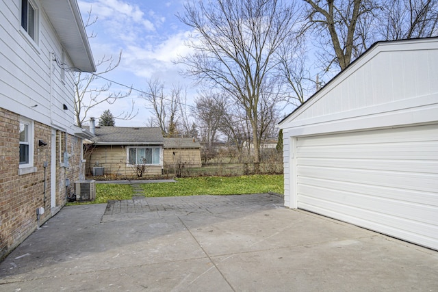 view of patio with cooling unit and a garage