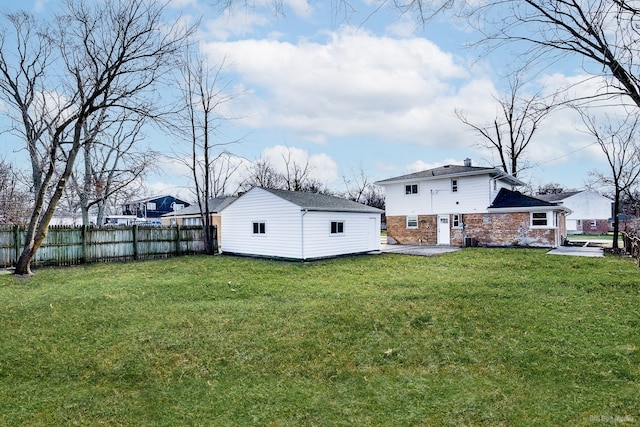 back of property featuring a lawn, a patio area, and an outdoor structure