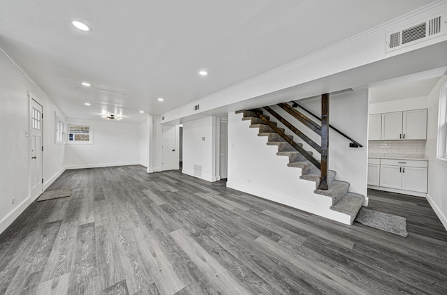 unfurnished living room featuring hardwood / wood-style flooring and crown molding