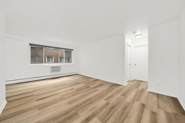 empty room featuring light hardwood / wood-style floors, a wall mounted air conditioner, and a baseboard heating unit