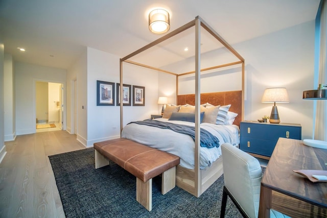 bedroom with hardwood / wood-style flooring and ensuite bath