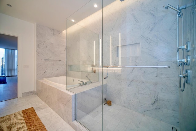 bathroom featuring shower with separate bathtub