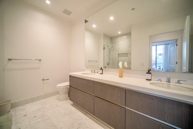 bathroom with vanity, toilet, and a shower with door